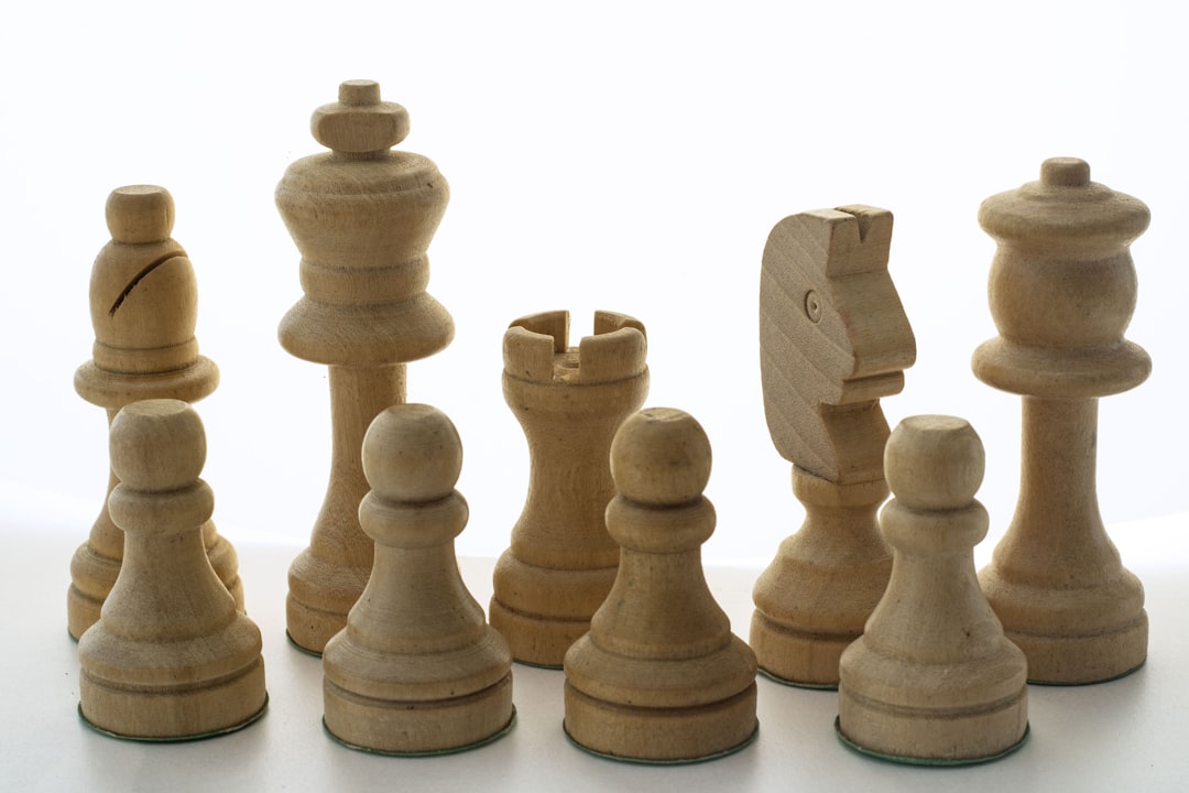 A group of wooden chess pieces on a white surface